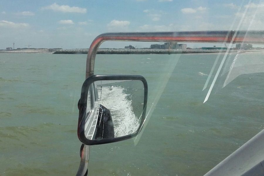 Met de visboot in de spiegel passeren we de nieuwe haven van Cadzand