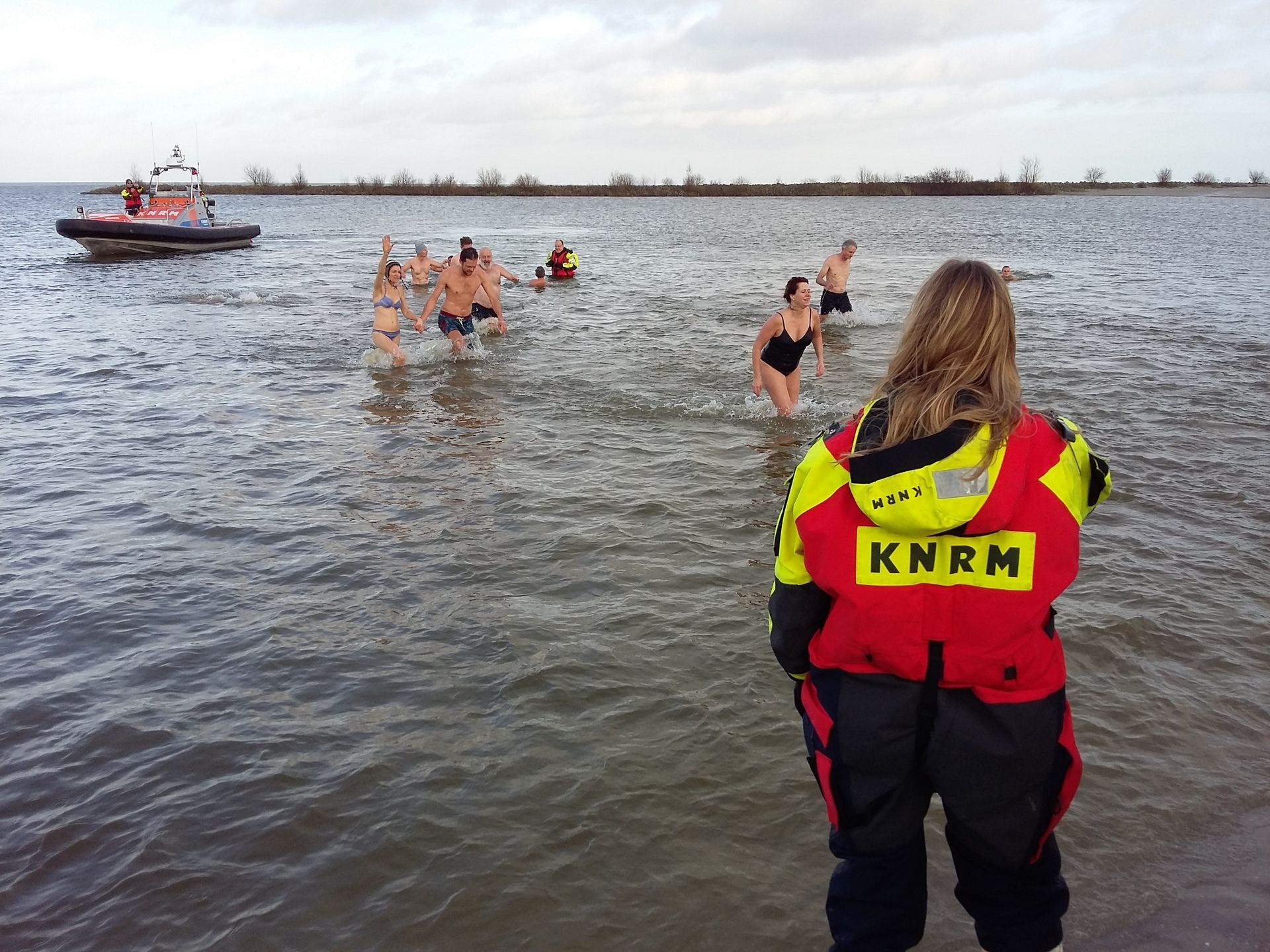 Bemanningsleden stonden paraat op het strand en in het water