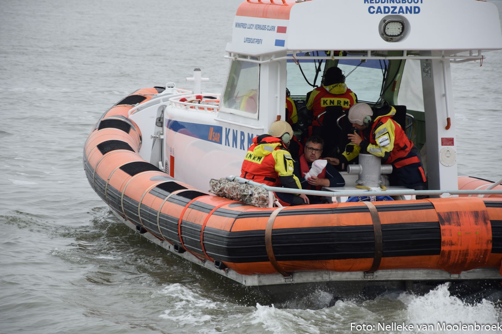 Het gewonde bemanningslid van de Callisto wordt door de reddingboot van Cadzand naar de ambulance ve