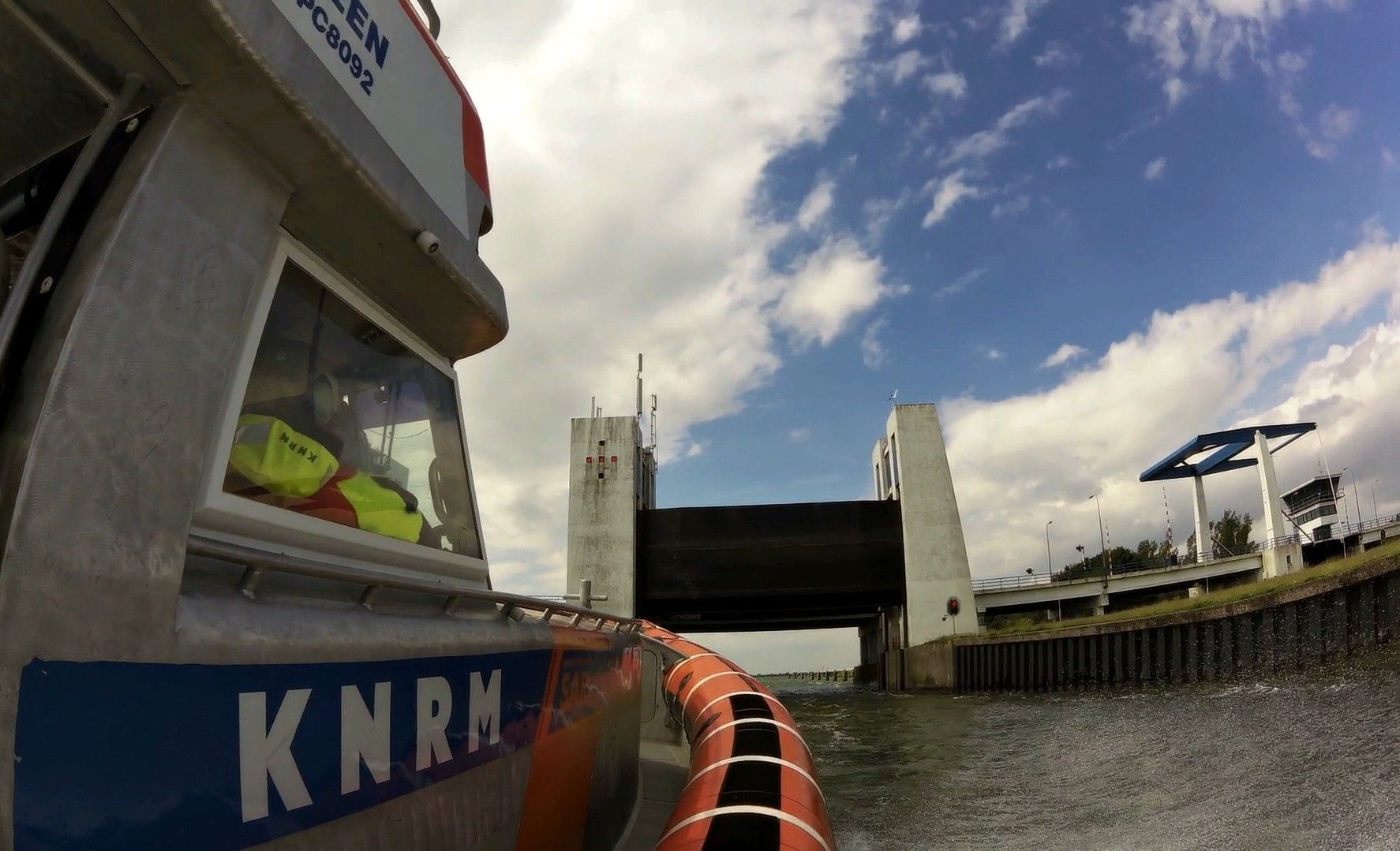 Reddingboot Watersport passeert met spoed het spuikanaal onderweg naar het Markermeer. KNRM Enkhuize